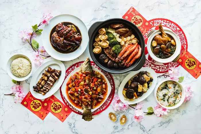 Chinese New Year catering spread with pen cai, braised duck, prawns and sweet and sour fish in Singapore