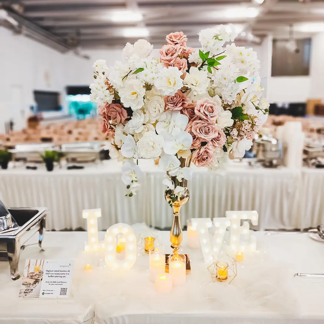 Wedding buffet catering setup with floral centrepiece and food warmers in Singapore